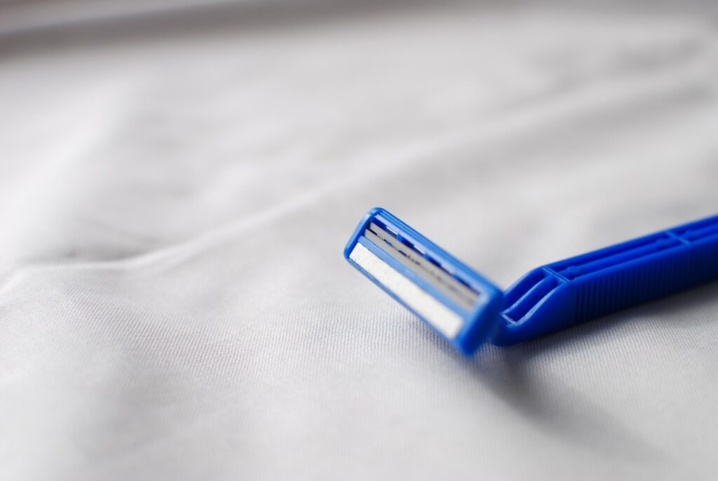 白い布の上に置かれたひげそり